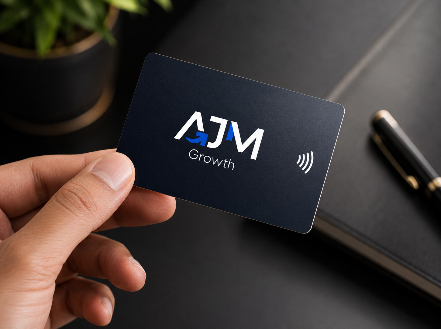 Cartão NFC preto com a logo da AJM Growth sendo segurado na mão
